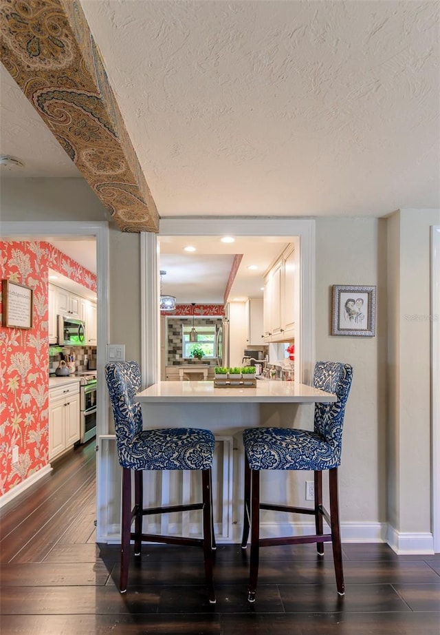 dining room featuring dark hardwood / wood-style flooring and a textured ceiling