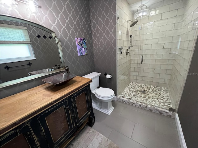 bathroom with toilet, vanity, tile patterned flooring, and a shower with door