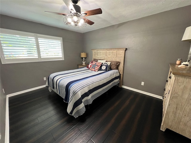 bedroom with dark wood-type flooring, ceiling fan, and a textured ceiling