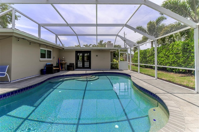 view of pool with a lanai, french doors, and a patio area