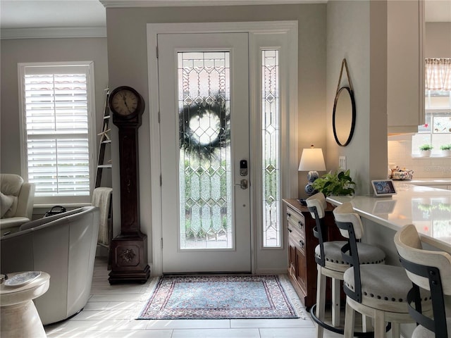 foyer featuring crown molding and plenty of natural light