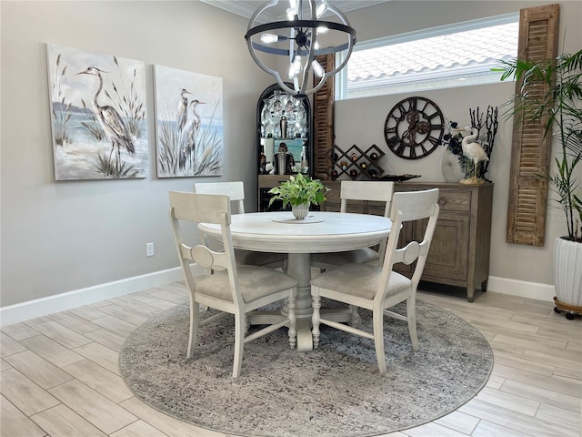 dining room with an inviting chandelier, ornamental molding, and light hardwood / wood-style flooring