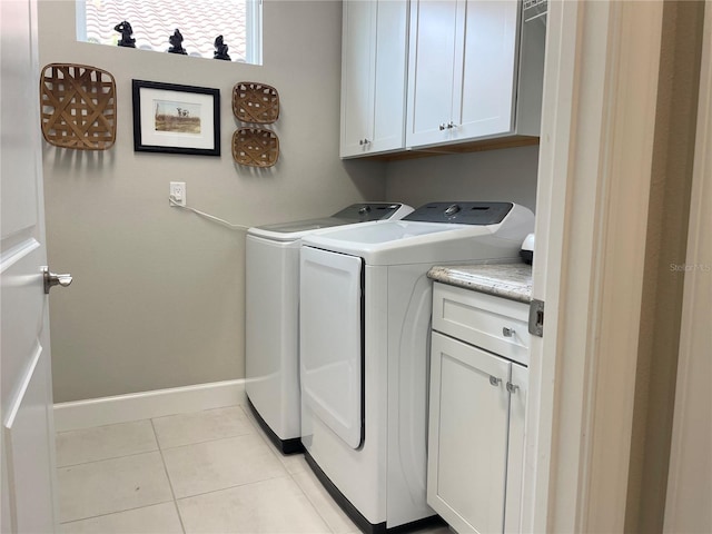 clothes washing area with cabinets, light tile patterned floors, and independent washer and dryer