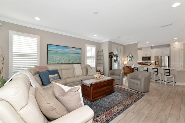 living room featuring crown molding and light hardwood / wood-style flooring