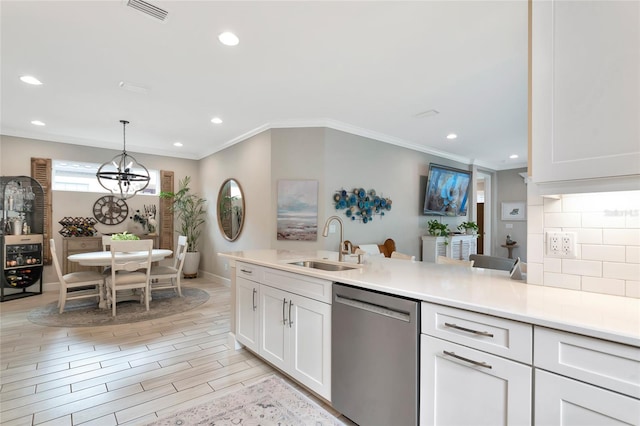 kitchen with pendant lighting, sink, white cabinetry, tasteful backsplash, and stainless steel dishwasher