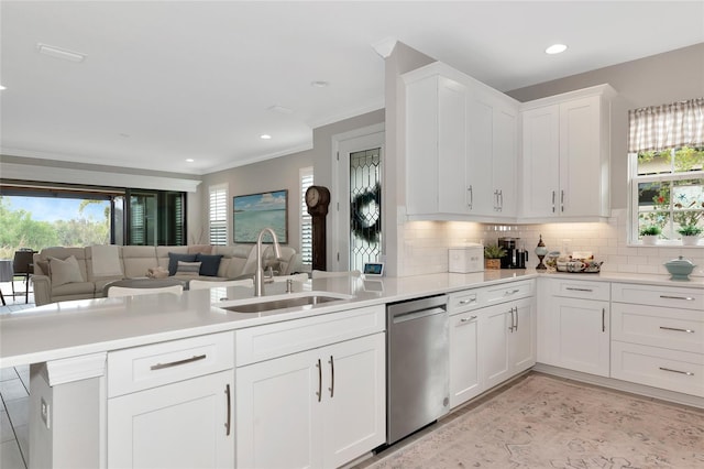 kitchen featuring sink, white cabinetry, plenty of natural light, stainless steel dishwasher, and kitchen peninsula