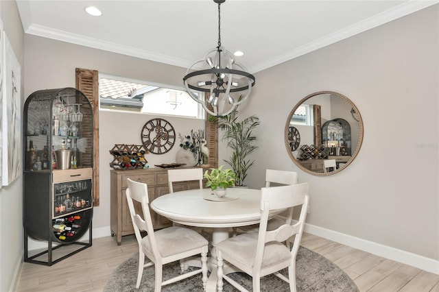 dining space featuring an inviting chandelier, ornamental molding, and light wood-type flooring