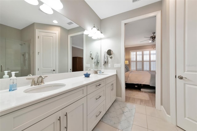 bathroom with ceiling fan, vanity, a shower with shower door, and tile patterned flooring