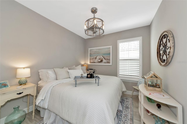 bedroom featuring an inviting chandelier and wood-type flooring