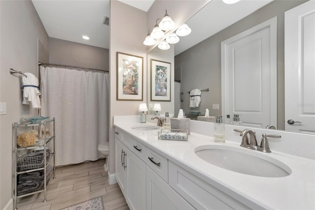 bathroom featuring vanity, walk in shower, and toilet