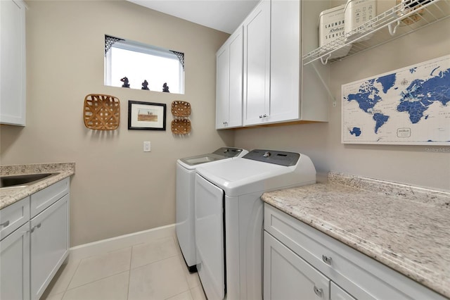 washroom featuring washer and dryer, sink, cabinets, and light tile patterned flooring