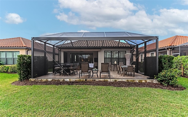 back of house with a yard, glass enclosure, and a patio area