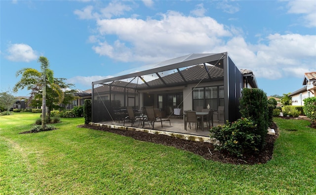 rear view of house featuring a patio, a yard, and glass enclosure