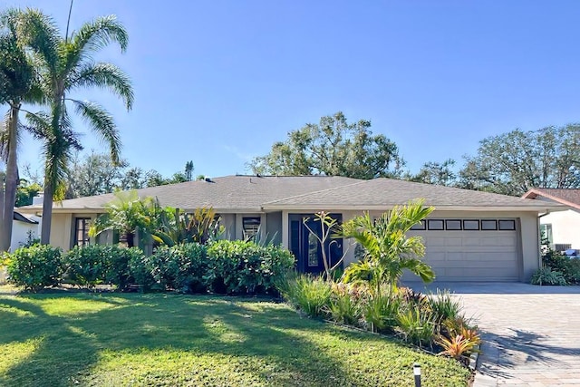 single story home featuring a garage and a front yard