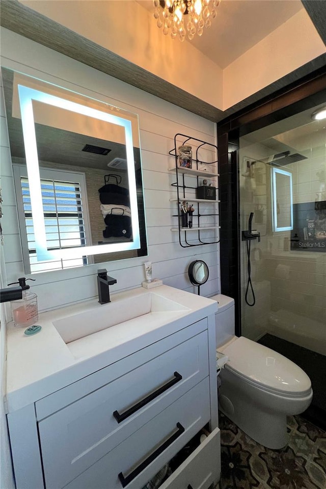 bathroom with vanity, toilet, tiled shower, and an inviting chandelier