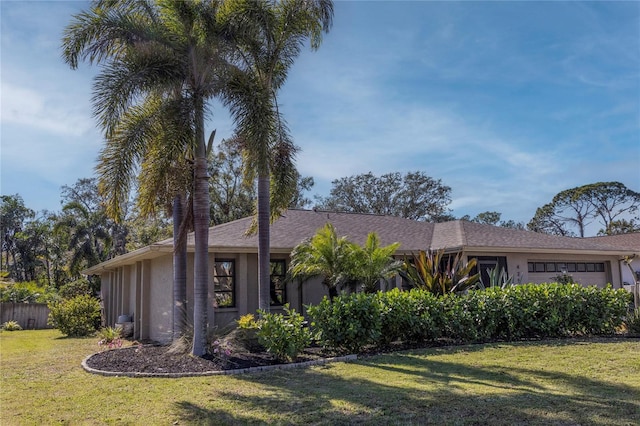 single story home featuring a garage and a front lawn