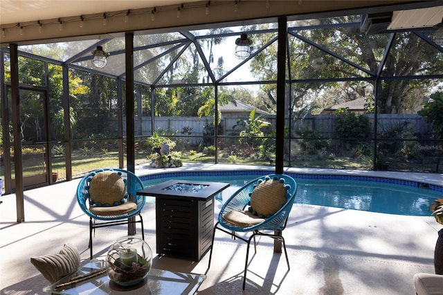 view of swimming pool featuring a fire pit, a patio area, and glass enclosure