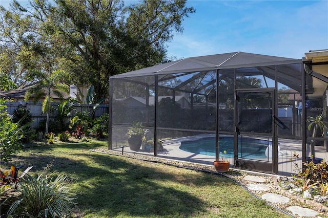 view of yard with a fenced in pool and glass enclosure