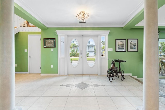 entrance foyer with ornamental molding, light tile patterned floors, and french doors