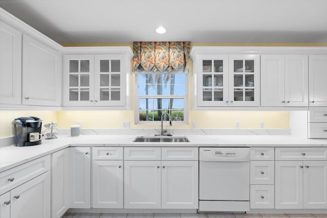 kitchen featuring white cabinetry, white dishwasher, sink, and light stone counters