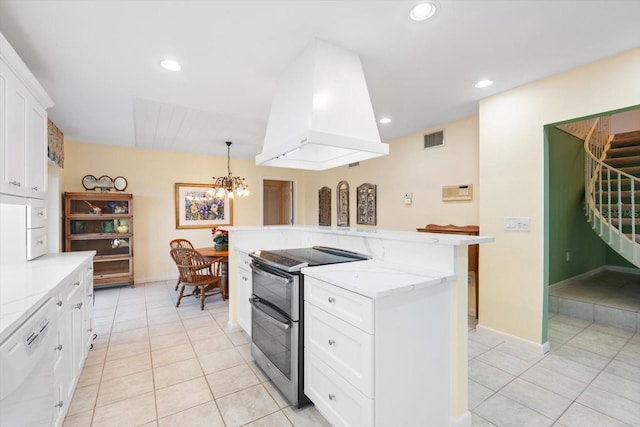 kitchen with pendant lighting, white cabinetry, light stone counters, island exhaust hood, and range with two ovens