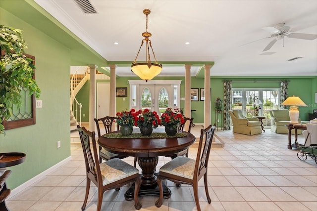 tiled dining area with french doors, ceiling fan, ornamental molding, and decorative columns