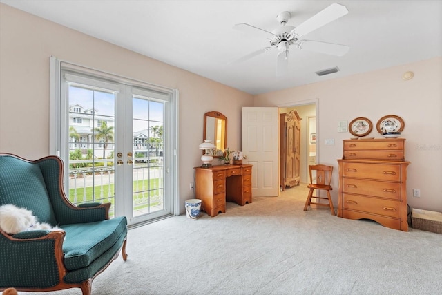 sitting room featuring light colored carpet, french doors, and ceiling fan