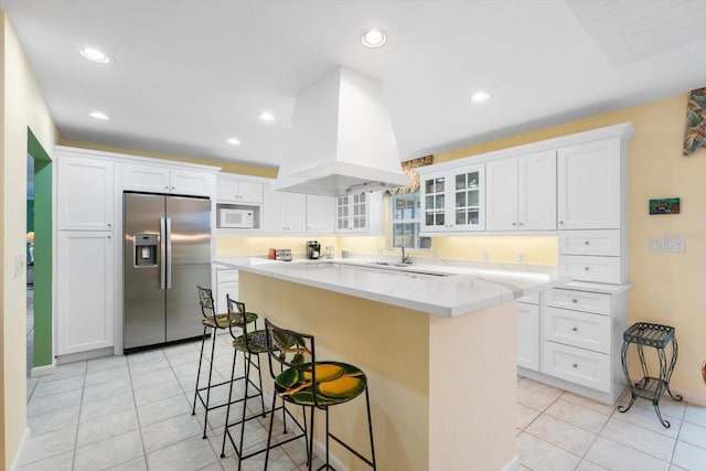 7056 Hawks Harbor Cir, Bradenton, FL 34207 - kitchen with white microwave, a kitchen island, island exhaust hood, a kitchen breakfast bar, and stainless steel fridge