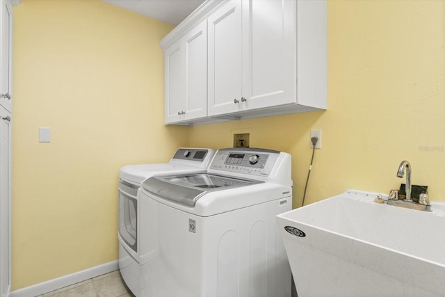 7056 Hawks Harbor Cir, Bradenton, FL 34207 - clothes washing area with washing machine and clothes dryer, baseboards, light tile patterned floors, cabinet space, and a sink