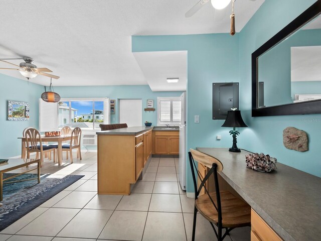 kitchen with ceiling fan, sink, light tile patterned floors, and kitchen peninsula