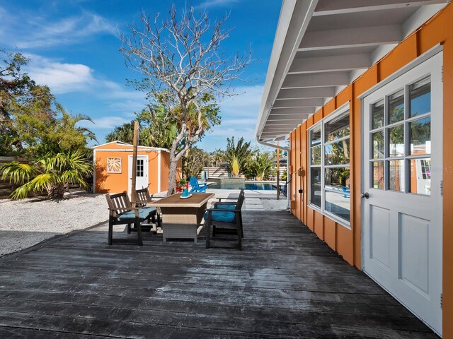 deck featuring a pool and a storage unit