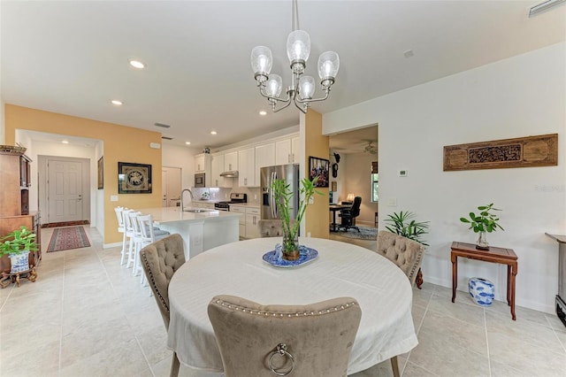 tiled dining room featuring sink and a chandelier