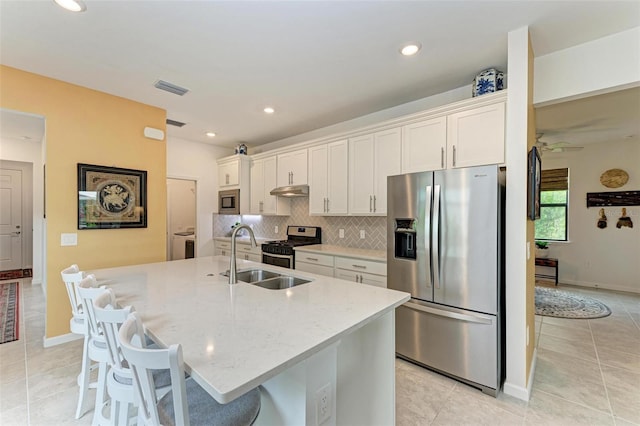 kitchen featuring white cabinetry, stainless steel appliances, and a kitchen island with sink