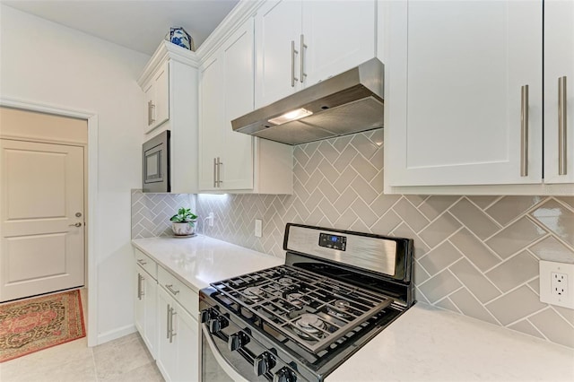 kitchen featuring white cabinets, stainless steel appliances, backsplash, light stone counters, and light tile patterned floors