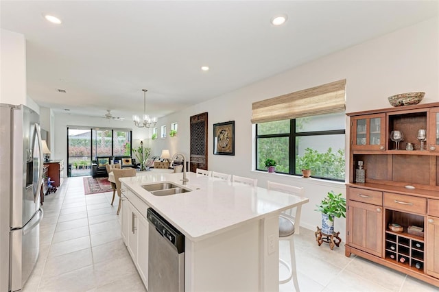 kitchen featuring white cabinetry, stainless steel appliances, sink, a kitchen island with sink, and light tile patterned floors