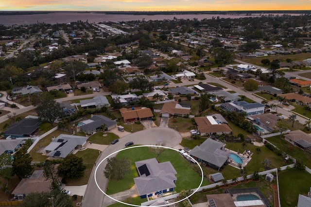 aerial view at dusk featuring a water view