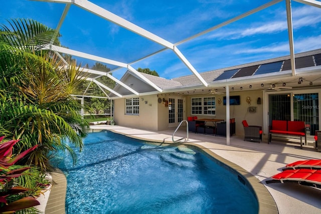 view of pool with an outdoor living space, glass enclosure, ceiling fan, and a patio