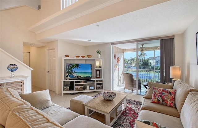 living room featuring ceiling fan, a wealth of natural light, light tile patterned floors, and a textured ceiling