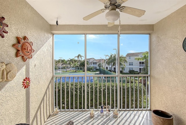 unfurnished sunroom featuring ceiling fan