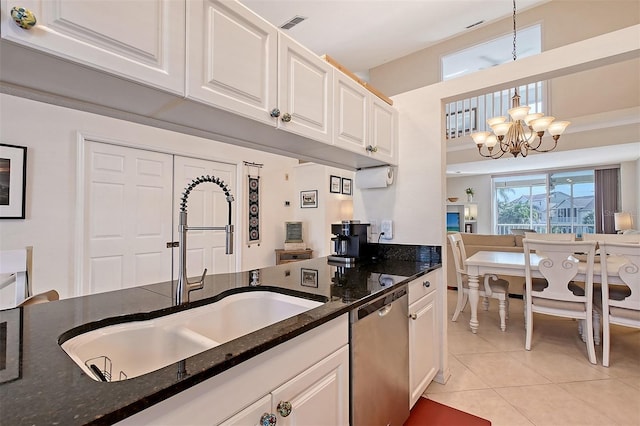 kitchen featuring pendant lighting, white cabinetry, dark stone counters, sink, and stainless steel dishwasher