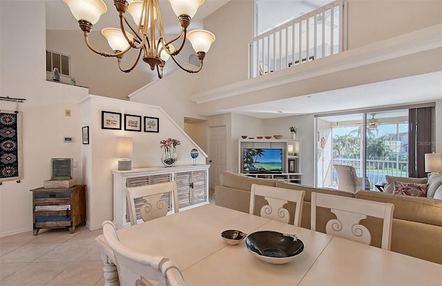 tiled dining room featuring a towering ceiling and an inviting chandelier