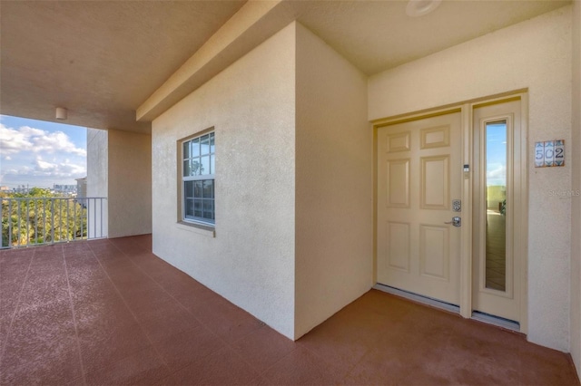 view of exterior entry with a balcony