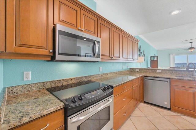 kitchen featuring ceiling fan, sink, light stone countertops, appliances with stainless steel finishes, and ornamental molding