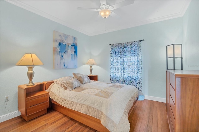 bedroom featuring ceiling fan, ornamental molding, and light hardwood / wood-style flooring