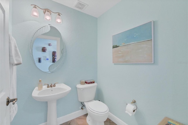 bathroom featuring sink, toilet, and tile patterned flooring