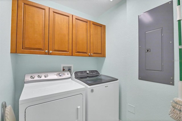 washroom with cabinets, electric panel, and independent washer and dryer