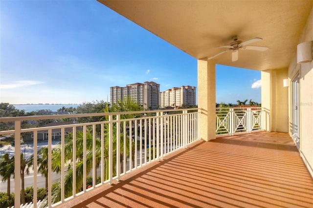 balcony with ceiling fan and a water view