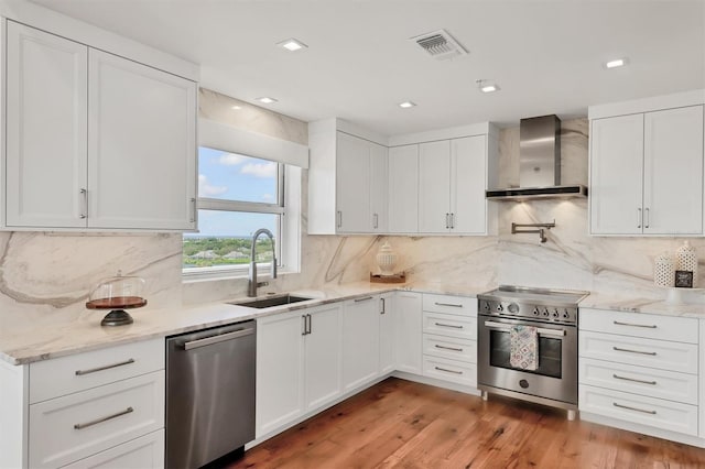 3060 Grand Bay Blvd Unit 175, Longboat Key, FL 34228 - kitchen with wall chimney exhaust hood, stainless steel appliances, a sink, white cabinets, and recessed lighting