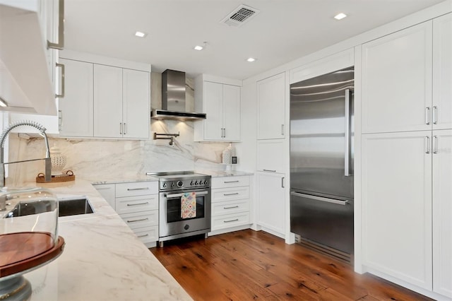 3060 Grand Bay Blvd Unit 175, Longboat Key, FL 34228 - kitchen with high quality appliances, wall chimney exhaust hood, white cabinetry, dark wood-style floors, and recessed lighting