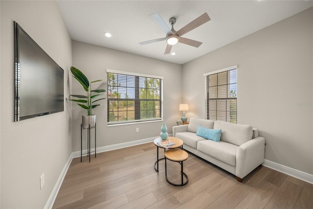 living room with light hardwood / wood-style floors and ceiling fan